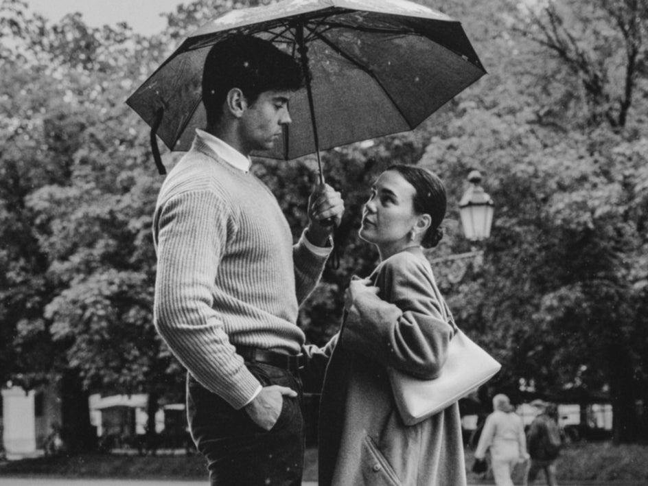 old black and white photo of couple with umbrella and background photobomber