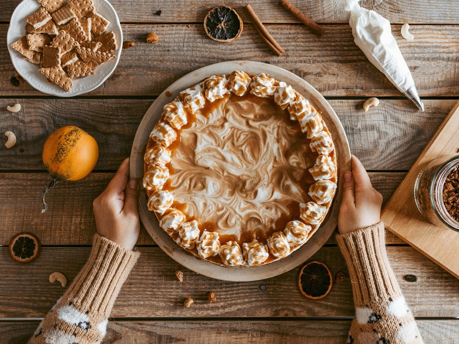 Before: Top-down photo of a baked pie on a rustic wooden table surrounded by baking clutter.