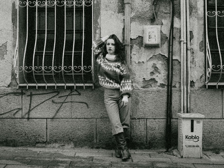 Before: A person walks down a city street with cluttered signage, cables, and pipes surrounding the scene.