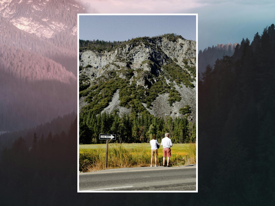 Before: One Way sign in the way of a scenic mountain photo with two hikers.